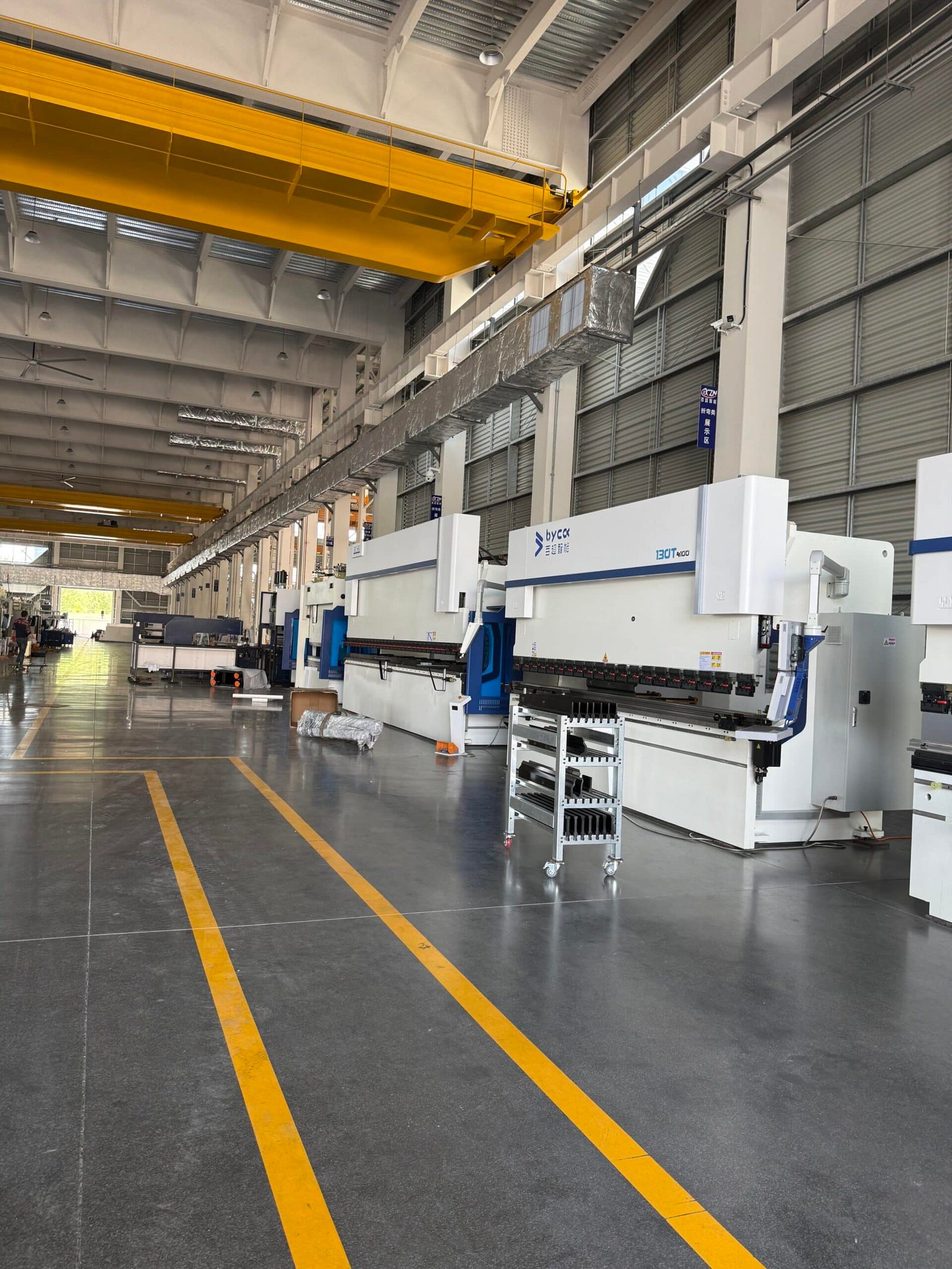 Metal fabrication workshop using CNC press brake with crowning system